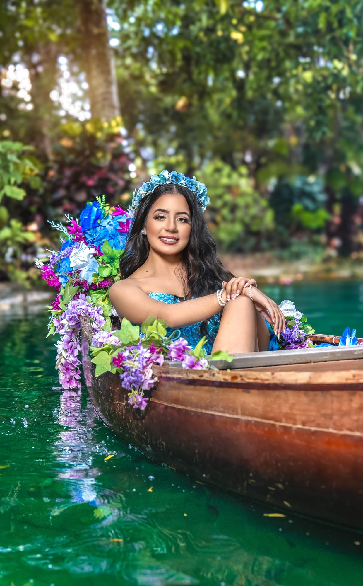Quinceañera in a canoe on a turquoise lagoon with tropical flowers