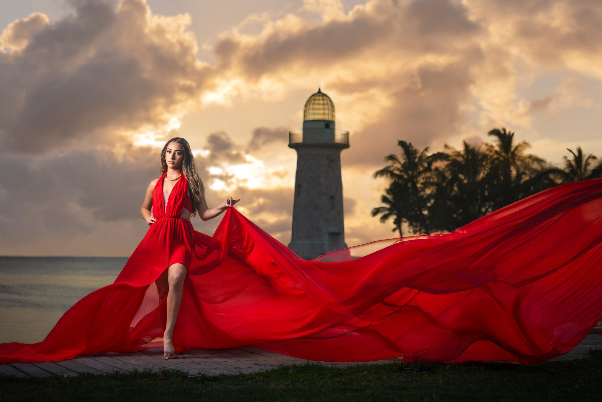 Quinceañera in a red flying dress at a lighthouse at sunset, Miami
